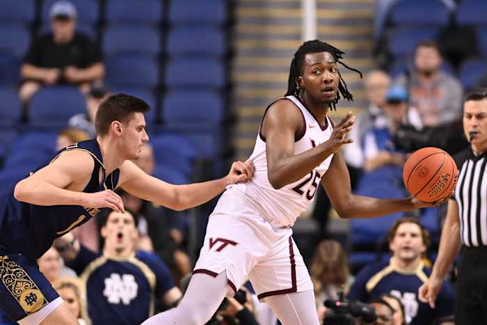 Mar 7, 2023; Greensboro, NC, USA; Virginia Tech Hokies forward Justyn Mutts (25) with the ball as Notre Dame Fighting Irish forward Matt Zona (25) defends in the first half at Greensboro Coliseum. Mandatory Credit: Bob Donnan-USA TODAY Sports